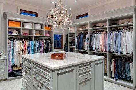 Walk-in closet with open cubbies over clothes rails centered on a gray closet island accented with crystal pulls and a white marble counter illuminated by a modern silver chandelier. Closet Chandelier, Transitional Closet, Organiser Son Dressing, Master Closet Design, Closet Island, Closet Planning, Walk In Closet Design, Open Closet, Build A Closet