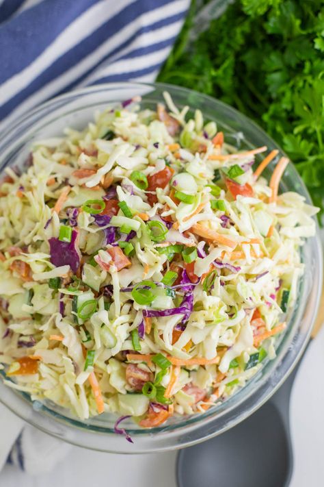 This Summer Slaw takes our family favorite southern coleslaw recipe and adds fresh summer vegetables, including cherry tomatoes, cucumbers, and green onions, and tosses it in a creamy, tangy dressing. Easy to make and a perfect summer side! Summer Slaw Recipe, Southern Coleslaw Recipe, Southern Coleslaw, Summer Slaw, Cabbage Slaw Recipes, Pea Salad Recipes, Coleslaw Recipe Easy, Coleslaw Salad, Homemade Coleslaw