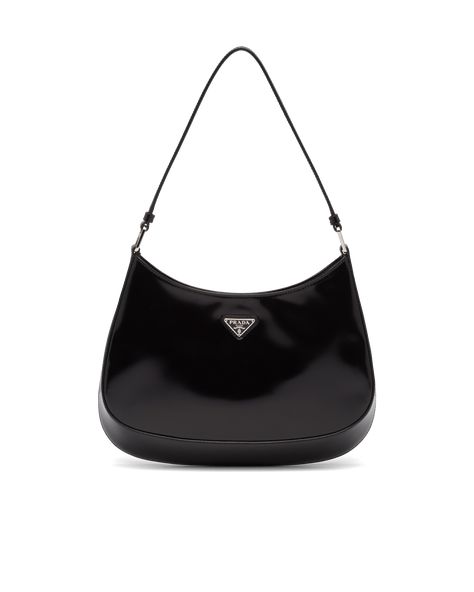 The Prada Cleo bag with sophisticated allure reinterprets an iconic design of the brand from the 1990's. Sleek curved lines emphasized by the particular construction rounded on the bottom and sides give this hobo bag a soft, light look. Brushed leather, a modern and versatile material that is distinctive in Prada collections, is ideal for creating always new combinations and contrasts. The enamel triangle logo decorates the silhouette. Prada Cleo Bag, Tas Prada, Cleo Bag, Tas Vintage, Prada Cleo, Tas Mini, Prada Collection, Hardware Logo, Bag Prada