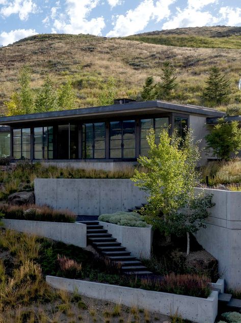 Keeping this house cozy and snug in the hillside was a key goal and outcome for this Idaho home. #hillsidehug #landscapearchitecture #retainingwalls House On Sloped Lot, Steep Hillside House, Houses On Hills, Mountain Spa, Hillside Homes, Architectural Homes, House On Slope, Dreamy Backyard, Garden Sitting Areas