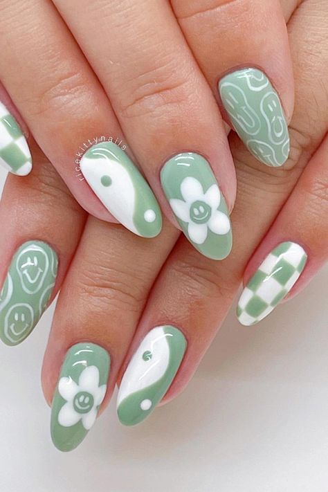 Stay trendy this summer with these adorable sage green almond nails, featuring a playful assortment of white designs including checkerboard patterns, smiley faces, daisies, and yin and yang symbols. Embrace the fun and bring out your unique style! ☯️ 🌸✨ // Photo Credit: Instagram @ricekittynails Paznokcie Hello Kitty, Kutek Disney, Unghie Sfumate, Funky Nail Art, Green Nail Art, Hippie Nails, Cute Simple Nails, Green Nail Designs, Nagel Tips