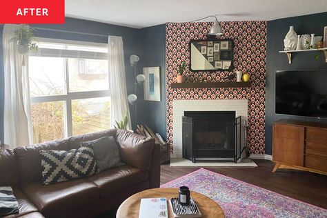 Living room/fireplace after makeover. Deep blue/gray painted walls, patterned wallpaper and white small square stick-on tiles around fireplace. Floating mantel shelf decorated with objets, small plant and rectangular mirror over that. Brown leather sofa with large window with white semisheer curtains behind. Wood credenza and TV to the right of the fireplace Wood Over Tile Fireplace, Wooden Mirror Over Fireplace, Dark Grey Wallpaper Fireplace, Peel And Atick Fireplace, Fireplace Ceramic Pattern Tile, Tile Around Fireplace, Floating Mantel Shelf, Wallpaper Fireplace, Fireplace Feature Wall