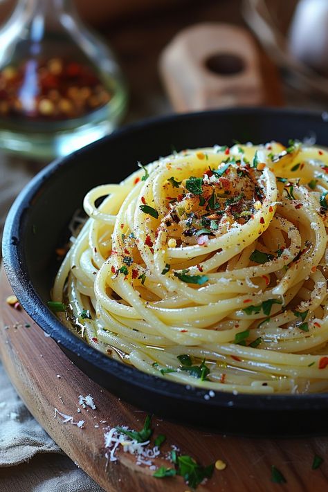 A delicious plate of spaghetti aglio e olio garnished with parsley, red pepper flakes, and grated cheese Aglio Olio Recipe, Aglio Olio Pasta, Garlic Olive Oil Pasta, Aglio E Olio Recipe, Spaghetti Aglio Olio, Spaghetti Aglio E Olio, Spaghetti Recipes Easy, Vegetarian Pasta Dishes, Spaghetti Aglio