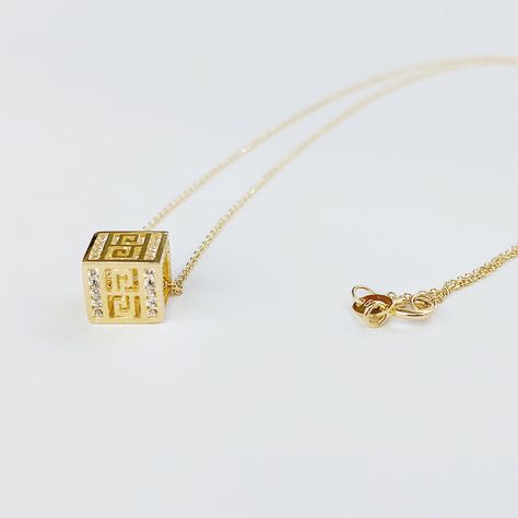 Greek key necklace in k14 gold, geometric symbol of eternity. The Greek meander necklace has a durable gold chain making the gold pendant necklace a lasting piece of jewelry. The historical design is perforated on the gold cube which is also decorated with cubic zirconia gemstones. The Hellenistic Meandros (Meander) is the ancient symbol of eternity. The eternity symbol decorates many ancient Greek monuments. An ideal gift for a classics lover. The gold necklace is delivered in a gift box. FREE Greek Monuments, Greek Meander, Gold Cube, Eternity Symbol, Key Charm Necklace, Geometric Symbols, Chain Making, Historical Design, Locket Charms