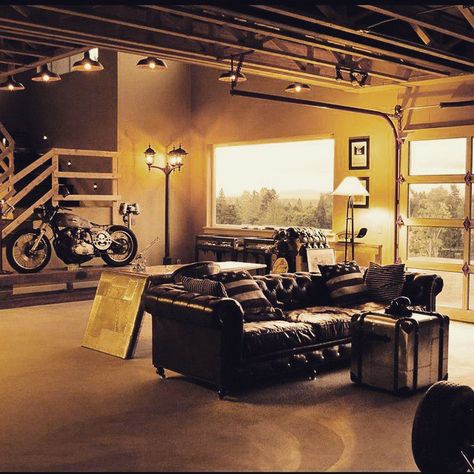 This #interiordesign shows that your #basement can showcase your #style as well as your #passion. The #v8 hums in the corner. The #masculinedesign #chesterfield invites you to stay. Better than any #mancave. #lookgoodandlivewell with your #motorcycle as #art #nikon #livingroom #polishedcementfloor Hybrid Office, Garage Bedroom, Motorcycle Garage, Office Garage, Formal Office, Shop Window Design, Man Cave Garage, Double Garage, Logo Vintage