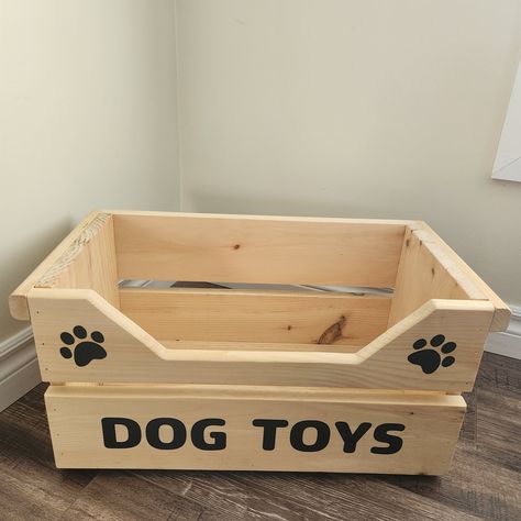 "This handmade wooden toy box looks great in any room and fits a variety of toys for big dogs and multiple dogs alike  This wooden dog toy box is made of pine and hand-finished with your choice of 8 water-based stains: American Walnut, Colonial Pine, Classic Black, Charcoal Grey, Light Grey, Ocean Blue, Hunter Green or Wood Rose. The beautiful character of each piece of wood is still visible through the stain. Dog box lettering is made with vinyl white or black lettering. Only enough room to say \"Dog Toys\".  **Please see other listing with wooden lettering** We've added a front cut-out to help dogs of all sizes be able to access their toys, even those at the very bottom.  Outside Approx. Dimensions: 19.5\" length, 10\" wide, and 10\" height.  Front Cut-Out Dimensions: approx. 10\" long x Wooden Dog Toy Storage, Wood Projects For Pets, Diy Dog Toy Box Ideas, Dog Toy Box Ideas, Dog Basket Ideas, Toys For Big Dogs, Personalised Wooden Toy Box, Wood Toy Box, Dog Room Decor