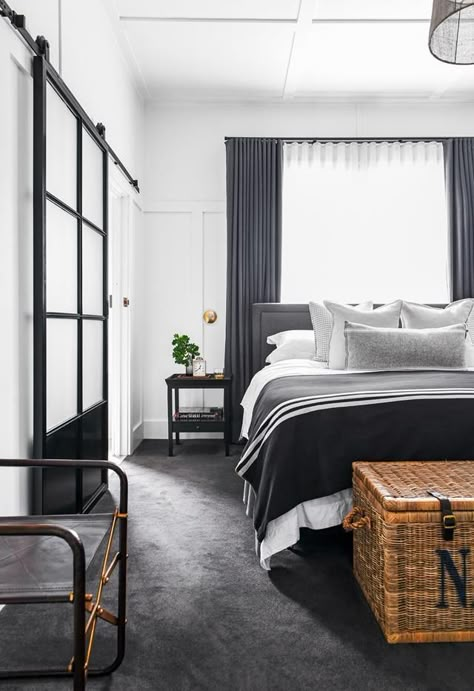 A main bedroom with black, white and grey colour scheme featuring black-framed steel sliding doors, black and grey bedding and grey curtains and carpet. Dark Grey Carpet Bedroom, Black And Grey Bedding, Black Carpet Bedroom, White Bedroom Decor Ideas, Black White And Grey Bedroom, Carpet Ideas Living Room, Black And White Bedroom Decor, Living Room Carpet Ideas, Room Carpet Ideas