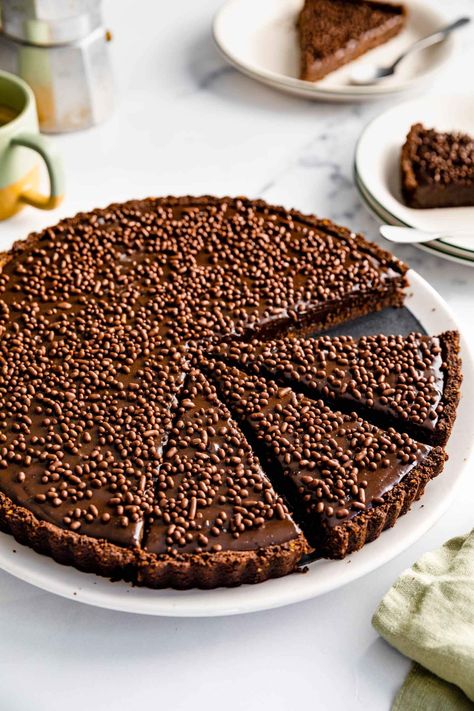 Brigadeiro Tart is one of our favorites. It's incredibly simple to make - the only thing that bakes it is the cookie cocoa crust. It's great for crowds, as it's filling, and this recipe serves 12 people. This layered dessert is made with delicious ingredients like condensed milk, chocolate, and sprinkles, and it’s the perfect dessert for Valentine's Day, Mother's Day, celebrations, or slow weekends. #jernejkitchen #brigadeiros #condensedmilk #chocolatetart #dessert #cookiecrust Brigadeiro Cake Recipe, Brigadeiro Cake, Graham Cracker Cookies, Famous Desserts, Layered Dessert, Small Bakery, Chocolate Pictures, Delicious Magazine, Mood Food