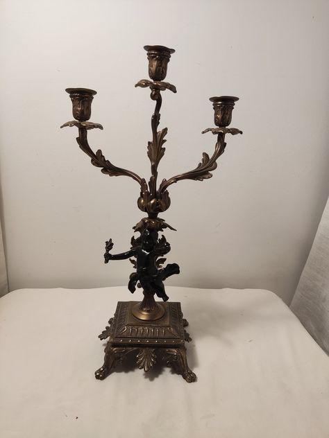 This is a vintage brass or copper angel, cherub candle holder on a pedestal, candle stand with three candle holders, good for decoration, collection, or gift ideas.  Condition:  good vintage condition except for some wear to the cherub body surface. see photos for the details. Size: 17.35" tall, 9.25" wide Weight: 1.91kg Please read the following carefully before placing an order 1.  Combined shipping is offered when purchasing multiple items 2.  Since this item cannot be returned once it is sol Candles For Bedroom, Cherub Candle, Three Candle Holder, Multiple Candles, Vintage Candle Holder, Candle Arrangements, Candle Stick Holders, Angel Cherub, Angel Candle Holder