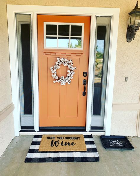 Farmhouse porch with burnt orange front door Front Door Colors Orange, Burnt Orange Exterior Door, Orange Trim House Exterior, White House Orange Door, Fun Door Colors Entrance, Tangerine Front Door, Orange Front Door White House, Dark Orange Front Door, Copper Color Front Door