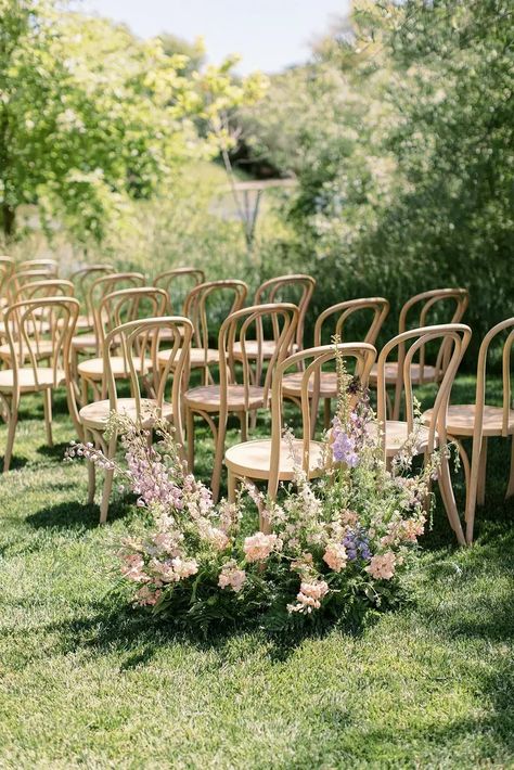 Light Wood Ceremony Chairs on Lawn With Pastel Flower Arrangements Spring Outdoor Wedding Ceremony, Wedding Flower Meadow, Pastel Aisle Flowers, Rustic Wedding Florals, Fairyland Wedding, Pastel Wedding Ceremony, Soft Spring Color Palette, Pastel Flower Arrangements, Wedding Ceremony Flower Arrangements