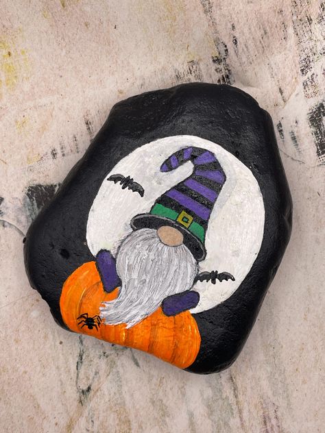 Glow in the Dark Moon with Gnome on Pumpkin, Halloween Decor, Painted Rock Stone Measures approximately:  Height 4" Length 3.75" Depth .75" ✽ My painted rocks are natural creek rocks collected locally in middle Tennessee and hand painted by me.  ✽ Your stones are handpicked and hand painted by me with love! Each is a one-of-a-kind piece of art! I hope they bring much joy, happiness, and a smile to you.   ✽ These are natural creek rocks so each stone is unique and no two rocks are identical.  The size, shape, and texture may vary slightly. ✽ Each stone design is drawn by hand, painted with acrylic paints, sealed, and packaged with care to send to your home from my home in middle Tennessee.   ✽ All my creations are sealed to protect and preserve the quality. ✽ Want a custom design?  If you d Halloween Gnomes Painted Rocks, Spooky Painted Rocks, Painted Rocks Halloween Ideas, Pumpkin Rocks Painted, Hocus Pocus Painted Rocks, Halloween Painted Rocks Ideas Easy, Halloween Gnome Painting, Halloween Rock Art, Fall Rock Painting Ideas