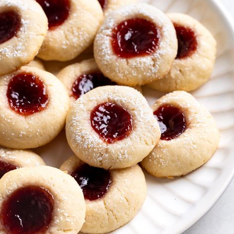 This recipe for one-bowl cream cheese thumbprint cookies features such simple ingredients, but the taste is anything but! An easy, quick-chilling dough bakes up perfectly tender and soft with a pool of raspberry jam in the center. They're a family favorite holiday cookie. Cream Cheese Cookies With Jam, 5 Ingredient Cream Cheese Cookies, Five Ingredient Raspberry Cheesecake Thumbprint Cookies, Thumbprint Cookies Cream Cheese, Cream Cheese Thumbprint Cookies Recipe, Cream Cheese Shortbread Cookies, Cream Cheese Thumbprint Cookies, Cheese Thumbprint Cookies, Cheesecake Thumbprint Cookies