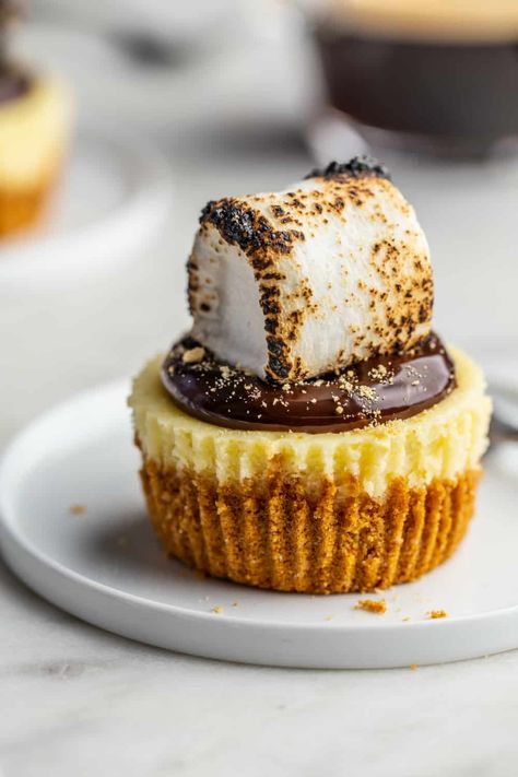 Decadent mini s’mores cheesecakes have the rich, creamy filling of traditional cheesecake in an individual serving size topped with fudge and marshmallow. #cheesecake #smores #marshmallow #dessert #sweet #campfiremarshmallows Smores Mini Cheesecakes, Mini S’mores Cheesecakes, Mini Cheesecake For Wedding, Mini Cheese Cakes Recipes, S’mores Cheesecake, Mini Smores, Smores Cheesecake, Traditional Cheesecake, Small Cheesecakes