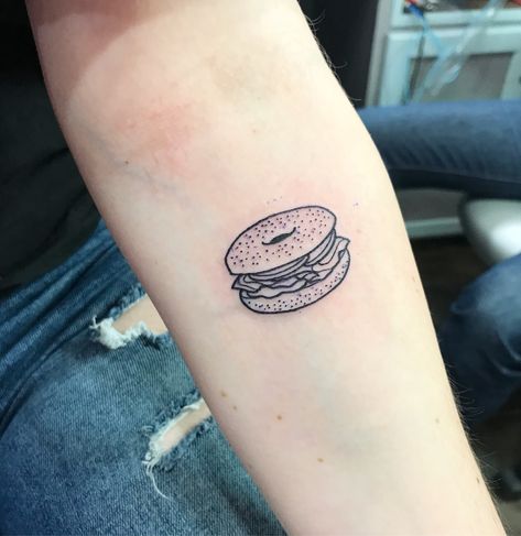 lox bagel tattoo done by James Eastwood at Insight Studios Chicago, IL Food Patchwork Tattoos, Everything Bagel Tattoo, Lunchbox Tattoo, Small Food Tattoos, Bagel Tattoo, Jewish Tattoo Ideas, Sandwich Tattoo, Foodie Tattoo, Lil Tattoo