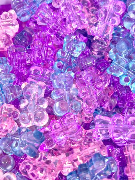 ♥  Embrace playfulness with our Translucent Gummy Bear Beads by Madison Beads. Fashioned in attractive pastel hues of pink, blue, and light purple, these beads are sure to infuse charm into your crafting projects. Perfectly resembling the fun shape of gummy bears, these translucent beads are ideal for creating distinctive jewelry, cute accessories, or unique décor items. Their appealing colors and unique design will undoubtedly elevate your creations. Crafted from high-quality, durable materials, these beads are designed to maintain their beautiful translucency and vibrant colors for a long time. Add a touch of whimsy to your crafting with our pastel-colored Gummy Bear Beads! ♥ Each gummy bear measures 18mm x 11mm, with a 1mm hole ♥ These gummy bears are made of resin Gummy Bears Aesthetic, Gummies Aesthetic, Gummy Bear Aesthetic, Pink Gummy Bears Wallpaper, Vibrant Colors Aesthetic, Purple Gummy Bears Aesthetic, Purple Gummy Bears, Pastel Vaporwave, Kawaii Multicolor Beaded Jewelry