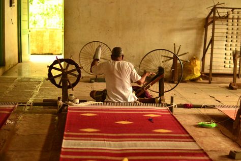 Traditional fabrication of khadi with a wheel Khadi Fabric, Fashion Editorial Layout, Weaving Machine, Geometric Pattern Art, Tanjore Painting, Diy Yarn Crafts, Fashion Design Sketchbook, Rigid Heddle Weaving, Indian Architecture