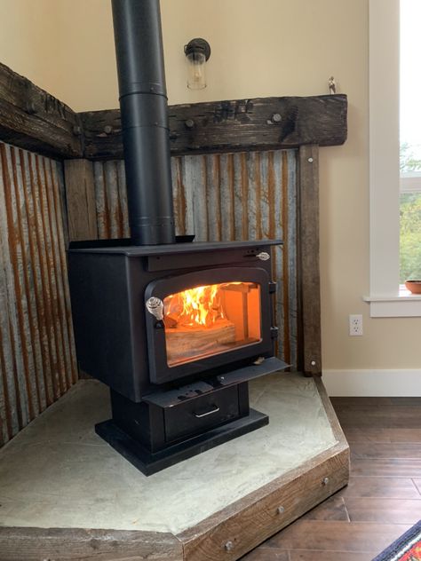 Wood Stove Tin Surround, Corrugated Metal Wood Stove Surround, Wood Stove Room Ideas, Rustic Hearth Ideas, Shed Fireplace, Rustic Wood Burning Stove, Wood Stove Metal Surround, Woodstove Surrounds Metal, Wood Stove With Mantle Behind