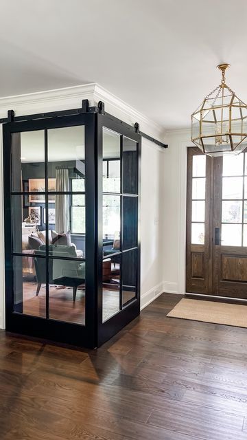 Lauren Zappitelli on Instagram: "Make an entrance!! 🖤 Corner. Barn. Doors. 🖤 In the original architectural plans there was a standard single door entrance to what would be a future office. Boring! Since the office was in the foyer, My clients and I decided to ‘make an entrance’ that was a little more dramatic than the standard barn door. And I think we pulled it off 😊 #doublebarndoors #barndoor #softclosedoors #frenchbarndoors #blackdoors #doorsofinstagram #doorsofdistinction #newconstruction Corner Sliding Glass Doors Office, Corner French Doors Office, Office French Doors Farmhouse, Office At Entrance Of House, Corner French Doors, Office Off Living Room French Doors, Office By Front Door, Corner Barn Doors In The House, Home Office With Glass Doors