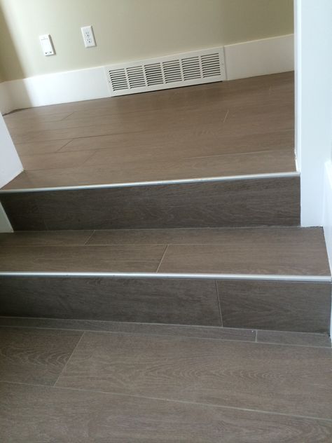 Wood floor tile on stairs with metal end cap Tiling Stairs, Wood Tile Stairs, Ceramic Stairs, Tile On Stairs, Wood Finish Tiles, Tiled Staircase, Floor Tiles Design, Flooring For Stairs, Beautiful Stairs