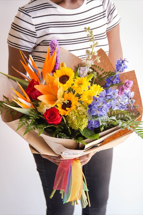 In honor of Pride Month, during the month of June we will be donating 10% of sales from the Love is Love bouquet to the Zebra Coalition, a local non-profit dedicated to supporting and inspiring LGBTQ+ youth. This gorgeous kaleidoscope of floral features all the colors of a beautiful rainbow by way of sunflowers, roses, tropical floral and more, artfully wrapped in kraft paper and hand-tied with rainbow ribbon. Shop Link Pride Flower Arrangements, Pride Bouquet, Love Bouquet, Rainbow Bouquet, Sunflowers Roses, Pride Event, Rainbow Ribbon, Garden Weddings, Flower Shops