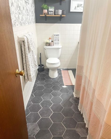 Faux-slate tiles can make any bathroom look sophisticated but on a budget. The dark tile is peel-and-stick but with intricate grout lines. Though not as durable, this type of tile is easy to lay and easy to take out when you're ready for something fresh and new. Black Hexagon Peel And Stick Floor Tile, Black Bathroom Tile Floor, Black Hexagon Tile Bathroom, Black Tile Bathroom Floor, Cement Bathroom Floor, Tile Types, Bathroom Floor Tile Ideas, Hexagon Tile Bathroom, Floor Tile Ideas