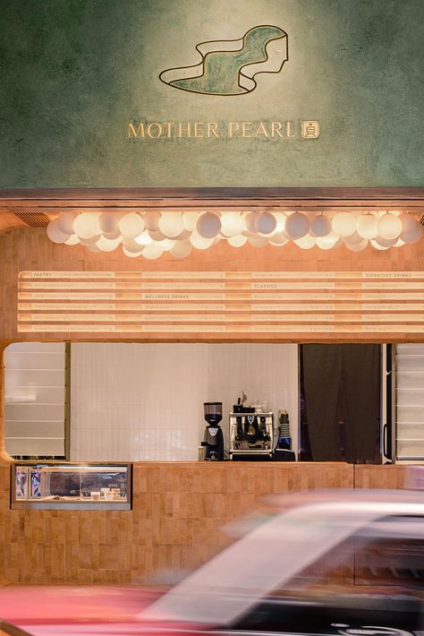 The dark olive green exterior of this tea house stands out against the other shops in the area, with the logo highlighted on the facade. Tea House Design, Concrete Effect Paint, Bubble Tea Shop, Green Exterior, Green Facade, Circular Lighting, Paper Hat, Signature Drinks, Tea Shop