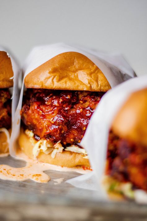 spicy Korean fried chicken sandwiches - SO MUCH FOOD Fried Chicken Burger Recipe, Kimchi Slaw, Sandwich Buffet, Protein Sandwich, Chicken Burger Recipe, Fried Chicken Sandwiches, Fried Chicken Burger, Spicy Fried Chicken, Fermented Cabbage