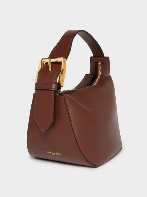 A new addition to the Quiver family, this dynamic-shaped bag is made from Wine smooth-calf leather. It has a simple zip closure and robust handle and features J&M D's statement brass buckle, and comes with a long detachable strap as well. H 14cm, W 22cm, D 16.5cm. Strap drop 55cm Buckle Bag, Buckle Bags, Transparent Bag, Statement Bag, Fancy Bags, Quiver, Unique Bags, Bag Trends, Brass Buckle