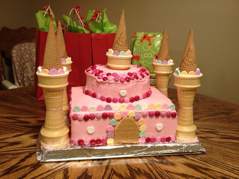 Easy to assemble pink princess castle cake (just the picture. Two square cakes, two smaller circles, graham cracker door, sugar cones and cake cones for the towers, candy for decoration.) Castle Cake Ideas, Easy Castle Cake, Easy Princess Cake, Castle Birthday Cakes, Princess Castle Cake, Cake In A Cone, Diy Birthday Cake, Novelty Birthday Cakes, Unique Birthday Cakes