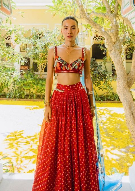 Bralette - handwoven silk, with hand embroidered florals in silk yarn with kashida and sozni, zardosi cutwork, sparkle and fun. Skirt - handwoven silk bandhini skirt with shells on the waistband. Dupatta - organza dupatta with beaten gold zardosi border and florals motifs in gold.. Red Bandhani Lehenga, Bandhani Skirt, Zardosi Border, Bandhani Lehenga, Chaniya Choli Designs, Silk Bralette, Bandhani Dupatta, Haldi Outfits, Designer Bridal Lehenga Choli