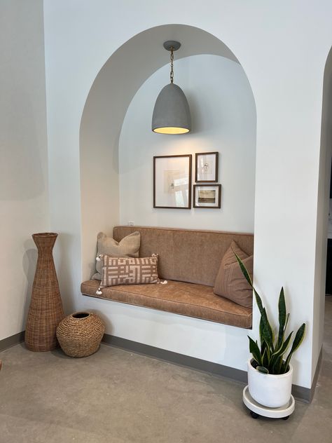 So in love with this special detail from a recent design install. We created an arched sitting nook for our clients to enjoym complementing it with a modern, warm light fixture + greenery and baskets for added coziness & texture!  #interiordesign #boho #moderndesign #neutralhome #arch #archeddoorway #gallerywall #plantaesthetic #neutralaesthetic #cozyaesthetic #cozyhome #fall #falldecor #fallaesthetic Arch Reading Nook, Bangalore House, Sitting Nook, Interior Design Classes, Esthetician Room Decor, Entryway Shelf, Esthetician Room, Mini Library, Lounge Ideas