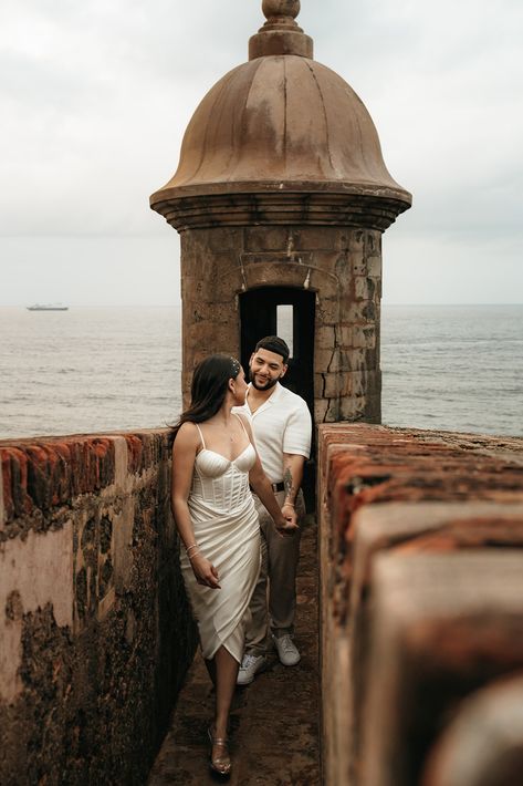 woman in white dress holding hand and leading him forward out of a Spanish fort. Engagement Photos Mission San Juan, San Juan Puerto Rico Engagement Photos, San Juan Photoshoot, San Juan Engagement Photos, Latino Engagement Photos, St Augustine Florida Engagement Photos, Engagement Photos Puerto Rico, Spanish Style Engagement Photos, Old San Juan Photoshoot