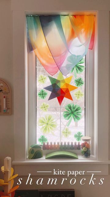 Stephanie Anderson on Instagram: "St. Patrick’s Day is just one week away, but these kite paper shamrocks/clover will stay up on our windows to soon welcome spring!🍀SAVE🍀to try making later!🌈☘️ Kite paper, Wood Craft Surface Board, Sarah’s Silk Rainbow Playsilk, Grimm’s rainbow goodies, Grapat Nins, and more all from @mymy.and.me PRAIRIE10 🌈 Wooden Sun Wand and Weather Station @the.playful.peacock PRAIRIE15 ☀️" Kite Paper Crafts, Paper Shamrocks, Waldorf Star, Waldorf Spring, Window Stars, Kite Making, Wooden Sun, Window Crafts, Nature Table