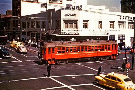 1940s: Pacific Electric car (possibly no. 1120) rolls through the 6th & Los Angeles Street intersection that plays host to a classic Greyhound Bus Station (northeast corner of 6th and Los Angeles) in this undated Robert T. McVay photo.  Update from Ralph Cantos:  This photo was taken from the north side of the 6th & Main elevated platform looking down on 6th Street as Pasadena bound car #1120 heads west to Main St. Railroad Industry, Old Los Angeles, Los Angeles Street, Red Cars, San Bernardino County, Riverside County, Hollywood Boulevard, Los Angeles City, Vintage Los Angeles