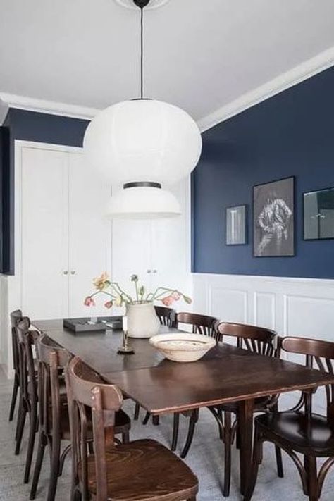 A dining room with white wainscoting and dark blue walls, vintage dining room table and chairs Dramatic Dining Room Colors, Living Room Wainscoting Ideas, Blue Dining Room Ideas, Living Room Wainscoting, Blue Wainscoting, Navy Blue Dining Room, White Dining Room Decor, Blue Dining Room Walls, White Dining Room Furniture