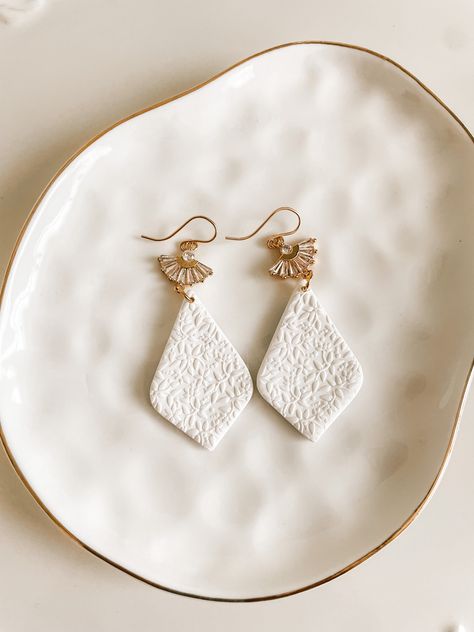 These handmade polymer clay earrings are designed to enhance the beauty of the bride on her special day.  The ear wire is 14k gold filled and hypoallergenic. The cubic zirconia fan attachment adds a touch of brilliance and elegance.  They are also comfortable to wear as they are lightweight.  These earrings are thoughtfully crafted to complement various bridal styles, whether it be a classic, modern, or bohemian look. With their classic design and attention to detail, these bridal earrings make Clay Earrings With Charms, Clay Wedding Earrings, Bridal Clay Earrings, Bridal Styles, Polymer Clay Jewelry Tutorials, Handmade Clay Jewelry, Polymer Earrings, Deco Earrings, Earrings Art