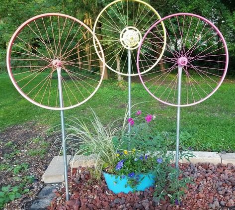 I saw my first bicycle wheel yard art a few years ago but couldn't find a how-to. My husband loves bikes so was onboard for this project and figured it out. It's actually pretty easy and inexpensive. Recently we put a bunch up on the fencing. And yes, they all spin! For this fencing version I've been considering painting a stem and leaves on the fence . Here we put a trio up against the house . .. They really do kinda look like flowers so we put the next grouping out in the yard… Whimsical Garden Art, Stepping Stones Diy, Garden Globes, Bicycle Wheel, Metal Yard Art, Metal Garden Art, Bicycle Art, Garden Art Projects, Bike Wheel