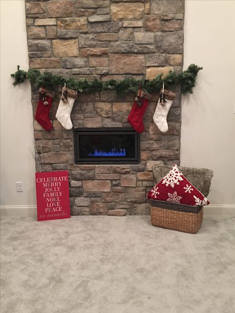 Creative way to hang Christmas stockings over a modern fireplace without a mantle. Use Avery 5lb silver hooks to hold a sparkly garland on each side of the stone wall. Wrap stockings by wrapping a branch through the stocking's loop. Stocking Over Fireplace, Hanging Stockings On Fireplace Without A Mantle, Stockings On Fireplace With No Mantle, Stockings Hung On Fireplace, Fireplace Decor Without Mantle, Christmas Fireplace Without Mantle, Fireplace Without Mantle Christmas, How To Hang Stockings Without A Mantle, Hang Stockings Without Mantle