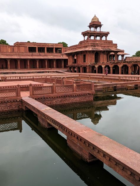 Fatehpur Sikri stands as a testament to the architectural brilliance of the Mughal era. Commissioned by Emperor Akbar in 1571, this once-thriving city was envisioned as a grand capital but was eventually abandoned due to water scarcity. Today, it remains frozen in time, its red sandstone structures echoing tales of emperors, saints, and cultural fusion. Indian Maximalist, Photography Buildings, Fatehpur Sikri, Architecture Photography Buildings, Red Sandstone, Mughal Architecture, Water Scarcity, Ganpati Decoration Design, Ganpati Decoration