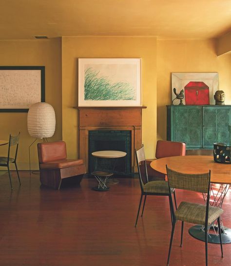 Italian-born painter Francesco Clemente favors bold earthy hues throughout, a palette inspired by the pigments in his own work. “He liked the idea of living among his frescoes”  In his dining room, mustard walls harmonize with a Twombly print, a Basquiat drawing (left) and one of the artist’s own paintings (right). Stronger colors, too, can act as surprisingly effective backgrounds for hanging art. “Petrol blue or chartreuse or acid yellow—those are really big color schemes at the moment.” Mustard Blue Living Room, Yellow Ochre Living Room, Ochre Dining Room, Ochre Living Room Colour Palettes, Yellow Ceiling Bedroom, Paint Color Schemes For Home Interior, Bold Interior Paint Colors, Yellow Wall Living Room Ideas, Interior Color Schemes Living Room