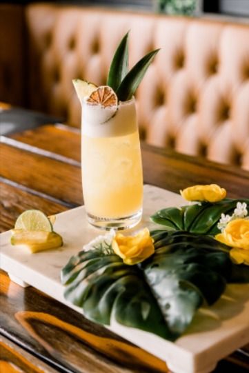 Margarita surrounded by palm leaves and yellow flowers. Pineapple Garnish Cocktails, Margarita Garnish, Peanut Butter Whiskey Cocktails, Pineapple Garnish, Tequila Sour, Pineapple Margarita Recipe, Business Hashtags, Peanut Butter Whiskey, Beer Goggles