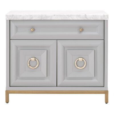 This gorgeous marble-topped media chest can function as a nightstand, media center, or accent cabinet. It is constructed with gray and white Italian marble and dove gray colored wood with brushed gold hardware. The back has a single hole, which is useful for cord management and tucking away unsightly wires. A felt-lined drawer and cabinet with adjustable shelving allow for ample storage space within this transitional-style cabinet. This would make a beautiful addition to any living room, bedroom Marble Veneer, Cabinet Interior, Shelf Dimensions, White Italian, Drawer Glides, Carrera Marble, Metal Drawer, Media Cabinet, Cord Management