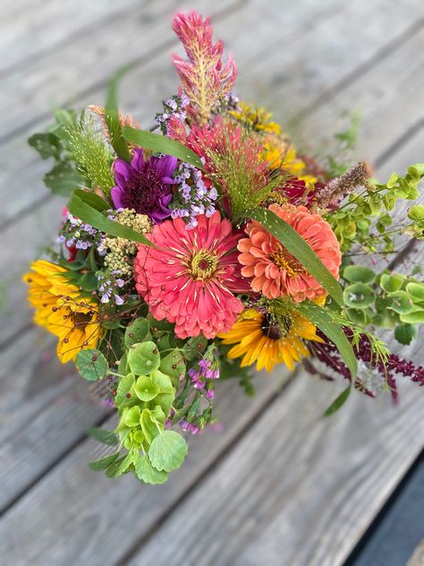 One of the many we offer for summer weddings, events, birthdays or just because.  This lovely bouquet contains salmon zinnias, green bells of Ireland, yellow sunflowers, purple dahlias, pink celosia and purple statice. Sunflower Market Bouquet, Zinnia Sunflower Bouquet, Sunflower And Zinnia Bouquet, Zinnia Boutonniere, Zinnias Bouquet, Zinnia Wedding Bouquet, Christmas Ideas Decoration, Hoco Bouquet, Market Bouquets