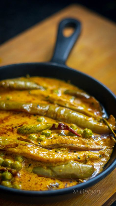 strips with ½ Tsp. of Turmeric Powder, ½ Tsp. of Kashmiri Red Chili Powder, ½ Tsp. of Sugar, and also ½ Tsp. of Salt. Heat the oil in a Pan and fry the eggplants at low temperature from all sides. Strain the fried Eggplants from the pan. Temper the oil with nigella seed and 2 dry red chilies. Add the mustard and curd mixture to it. Add Green Peas followed by green chilies as well and bring it to a boil. Now add Turmeric powder, sugar, red chili powder, and also salt. Now add fried Eggplants ... Best Indian Vegetarian Recipes, Dry Vegetable Recipe, Red Mustard Greens Recipe, Green Bean Curry, Eggplant Recipes Healthy, Green Eggplant, Eggplant Curry, Bengali Food, Recipe Step By Step