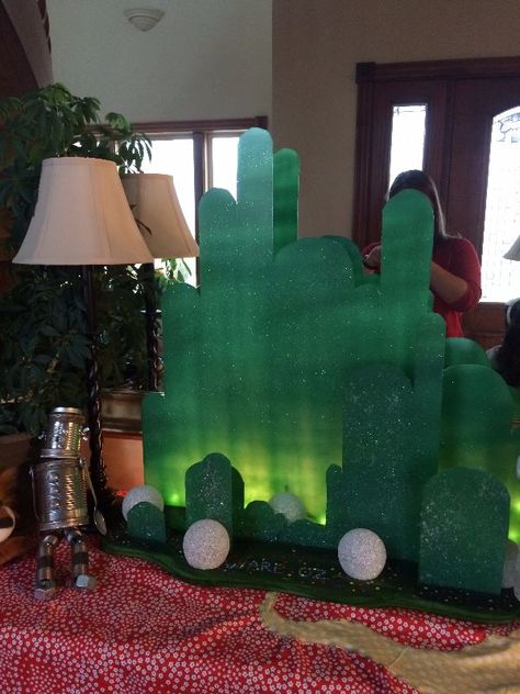 Light up Emerald City I made of Plexiglass. I cut it out with a scroll saw, and spraypainted it. While the spray paint dried I sprinkled glitter all over it. I also made the wood base that the plexiglass peices fit into. Wicked Centerpiece, Wizard Of Oz Halloween, Wicked Party, Halloween 2015, Cut It Out, Emerald City, Scroll Saw, Wizard Of Oz, Spray Paint