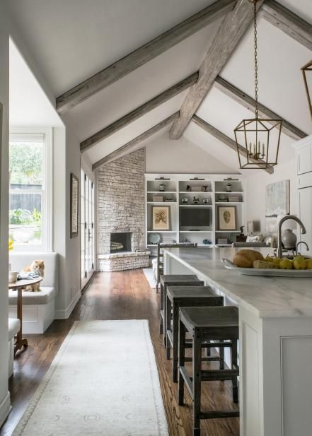 With vaulted ceilings, marble surfaces and crisp white cabinetry, this contemporary kitchen remodeled by Julie Bradshaw seems light and airy. Wood floors and nature-inspired prints add a rustic touch to the space. Farmhouse Fireplace Ideas, Rustic Farmhouse Fireplace, Modern Köksdesign, Contemporary Kitchen Remodel, Vaulted Ceiling Kitchen, Open Kitchen And Living Room, Farmhouse Fireplace, Corner Fireplace, Kitchen And Dining Room