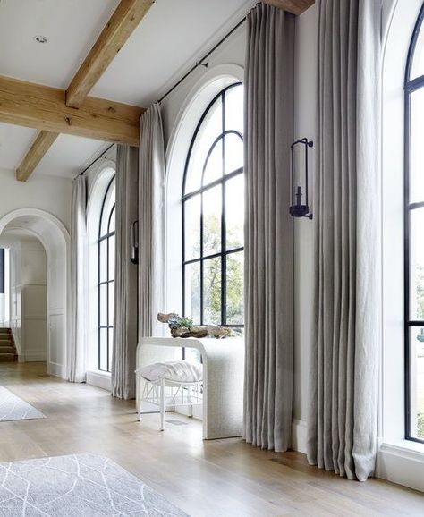 Floor to ceiling drapes around these arched black window frames. Hardenburg Designs Arched Window Coverings, Curtains For Arched Windows, Arched Window Treatments, Black Window Trims, Black Window Frames, Modern Window Treatments, Modern Farmhouse Home, Unique Flooring, Custom Drapes