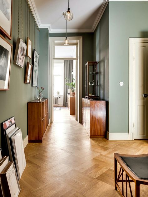 The way the pictures are hung really intrigues me. Wooden Floor Wall Color, Green Hallway, Stockholm Apartment, Hallway Colours, Hallway Flooring, 아파트 인테리어, Parquet Flooring, Room Interior Design, Hallway Decorating