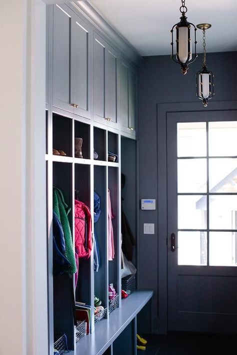 Dark blue mudroom features a row of blue cabinets adorned with brass knobs stacked atop open blue mudroom lockers lined with vintage metal locker baskets. Cabinet Mudroom, Mudroom Lighting, Mudroom Layout, Blue Mudroom, Mudroom Cabinet, Mudroom Paint, Mudroom Paint Color, Blue Cabinetry, Jean Stoffer Design